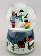 Boules à neige musicales de Noël disponibles sur commande (nous contacter) Boule à neige musicale animée de Noël avec globe en verre et deux enfants construisant un bonhomme de neige