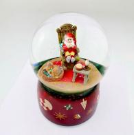 Boules à neige musicales de Noël disponibles sur commande (nous contacter) Boule à neige musicale de Noël avec globe en verre, paillettes et lutin assis sur un rocking-chair