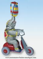 Jouets mécaniques en métal, tôle ou fer blanc Jouet mécanique en métal, tôle et fer blanc : jouet mécanique éléphant sur vélo rouge