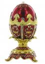 Oeuf musical de style Fabergé en métal: oeuf musical rouge avec dorures, strass et 4 pieds